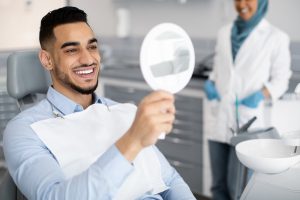 Man sees smile in mirror at dental office.